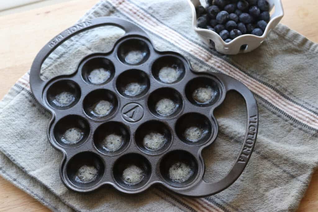 cast iron pan with oil in it to cook the Freshly Milled Fluffy Lemon Blueberry Pancake Bites