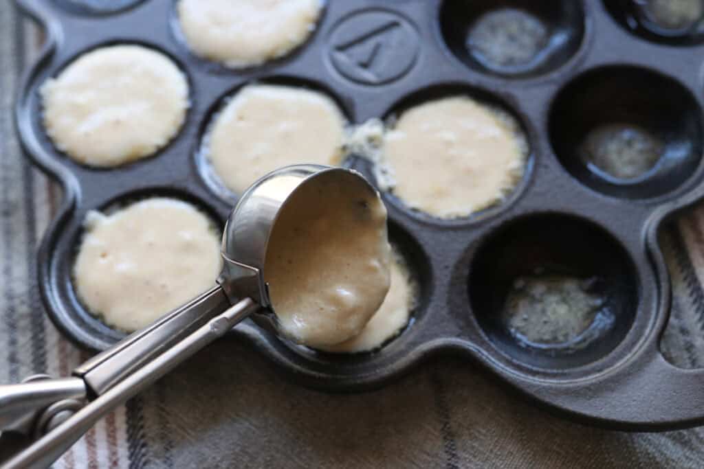 scooping Freshly Milled Fluffy Lemon Blueberry Pancake batter into  a pan 