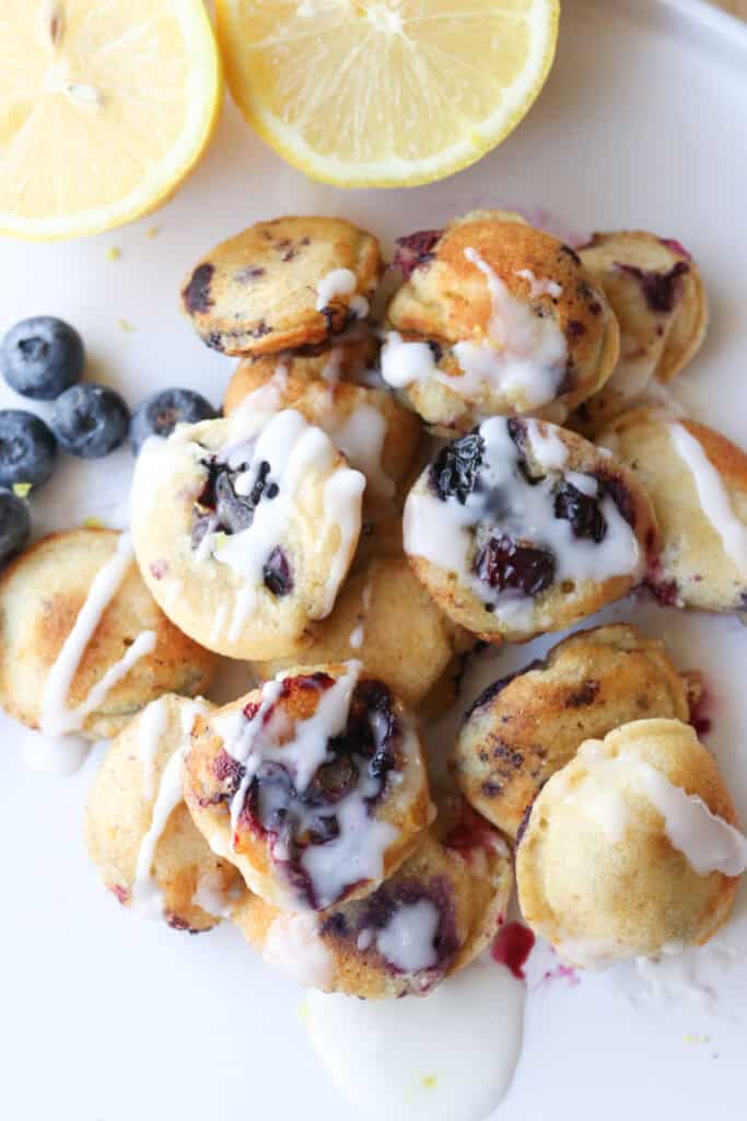 Freshly Milled Fluffy Lemon Blueberry Pancake Bites topped with glaze and fresh berries
