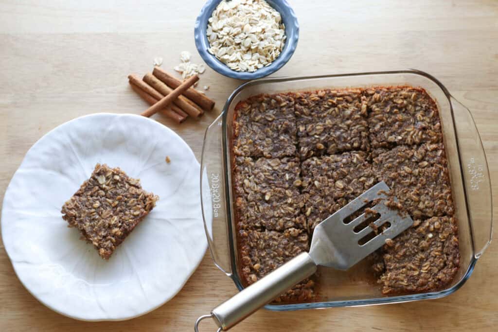 healthy and homemade chai baked oatmeal in a glass dish with a piece on a white plate
