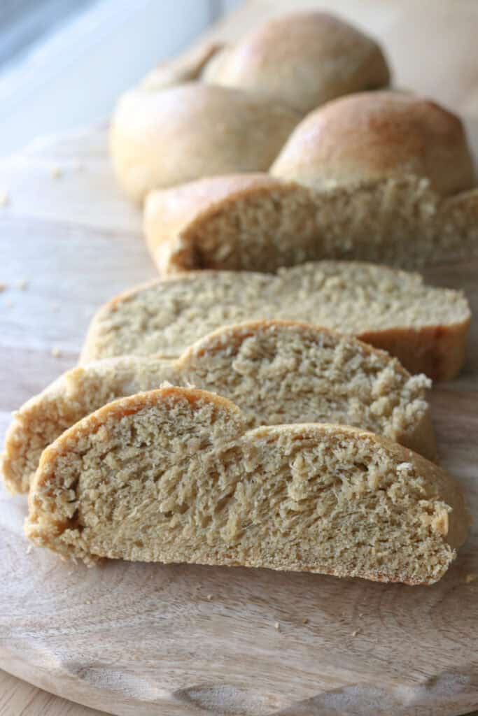freshly milled braided challah bread that has been sliced into 3 pieces