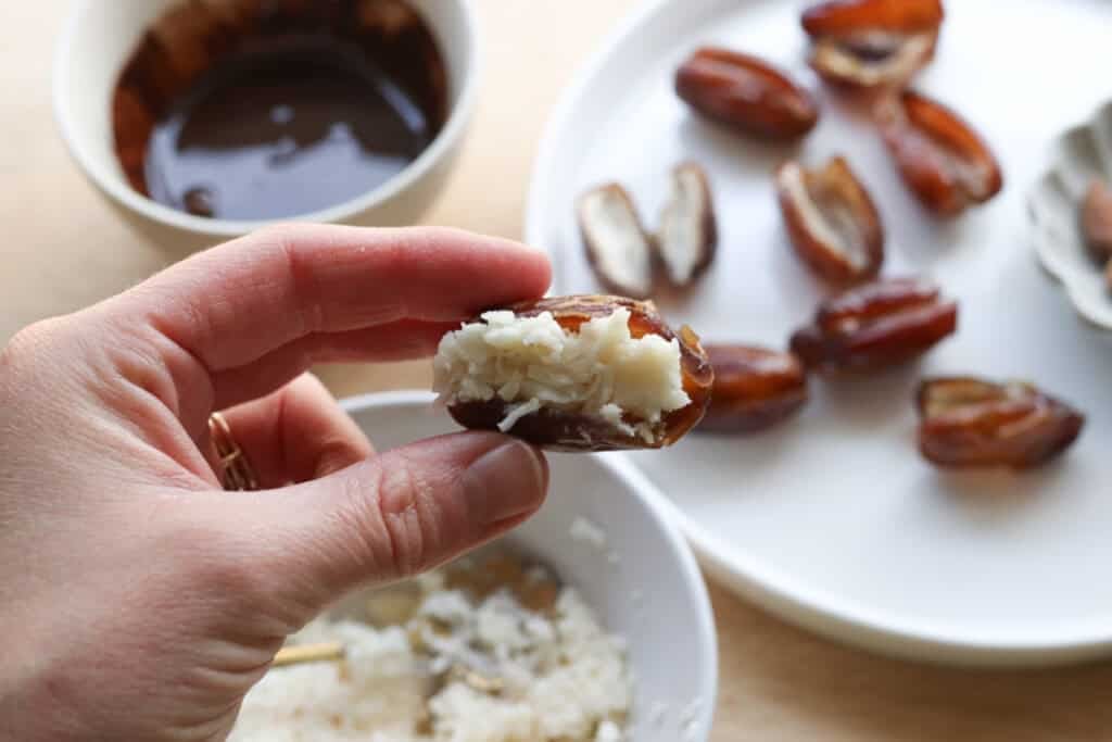 stuffing an almond joy date with coconut butter and shredded coconut