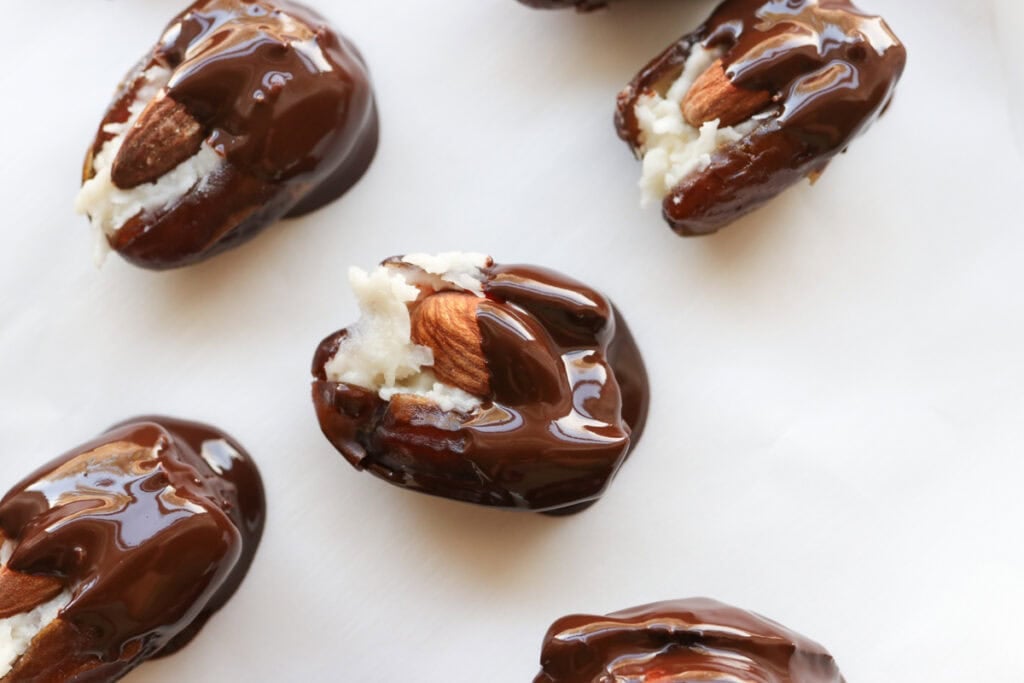 Healthy Almond Joy Stuffed Dates that have been dipped in chocolate