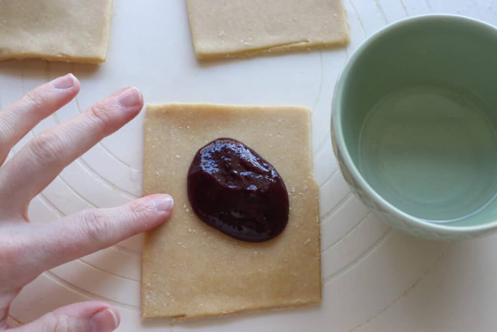 rubbing water on the edge of a freshly milled pop-tart so it seals