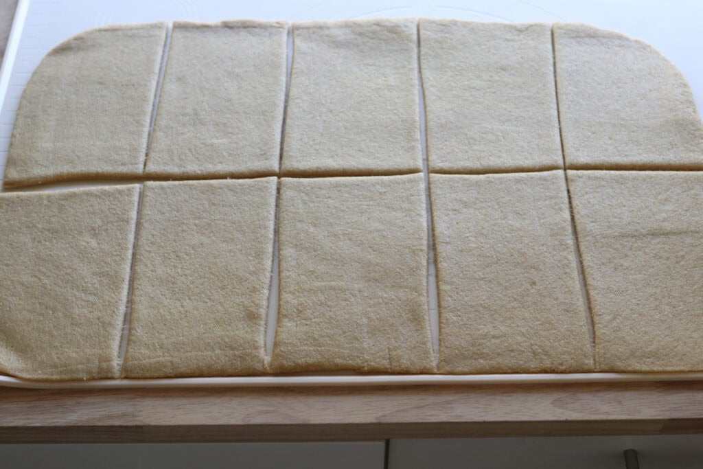 Fresh milled cheesy taco pocket dough cut into 10 rectangles