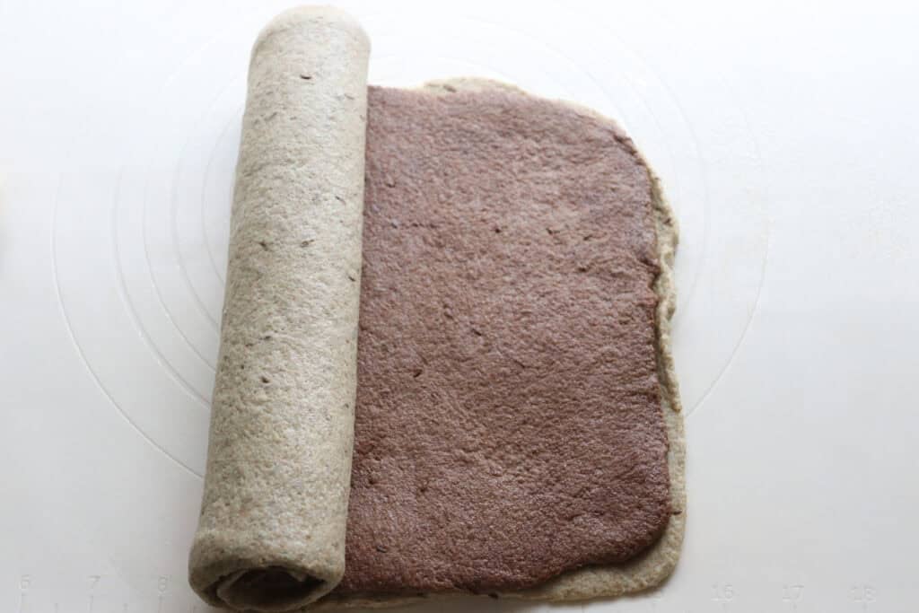 rolling to layers of dough together for freshly milled marbled rye bread