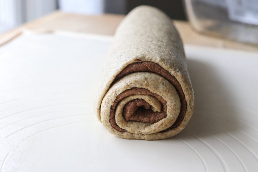freshly milled light and dark rye dough that has been stacked together and rolled into a log