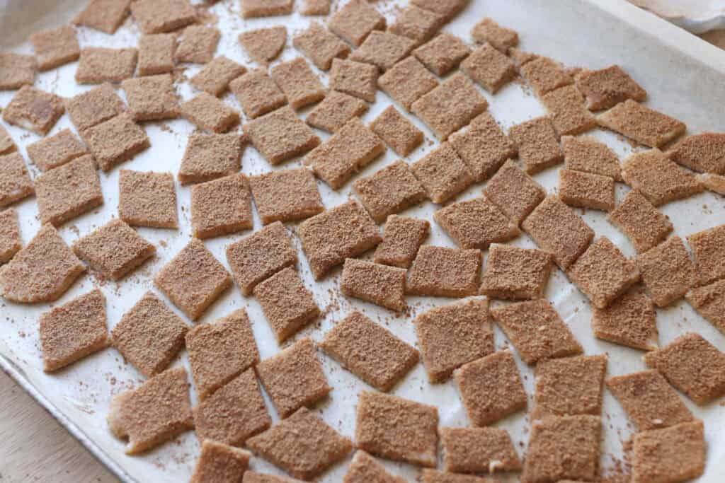 Homemade Fresh Milled Cinnamon Toast Crunch Cereal on a baking sheet with parchment paper getting ready to bake in the oven