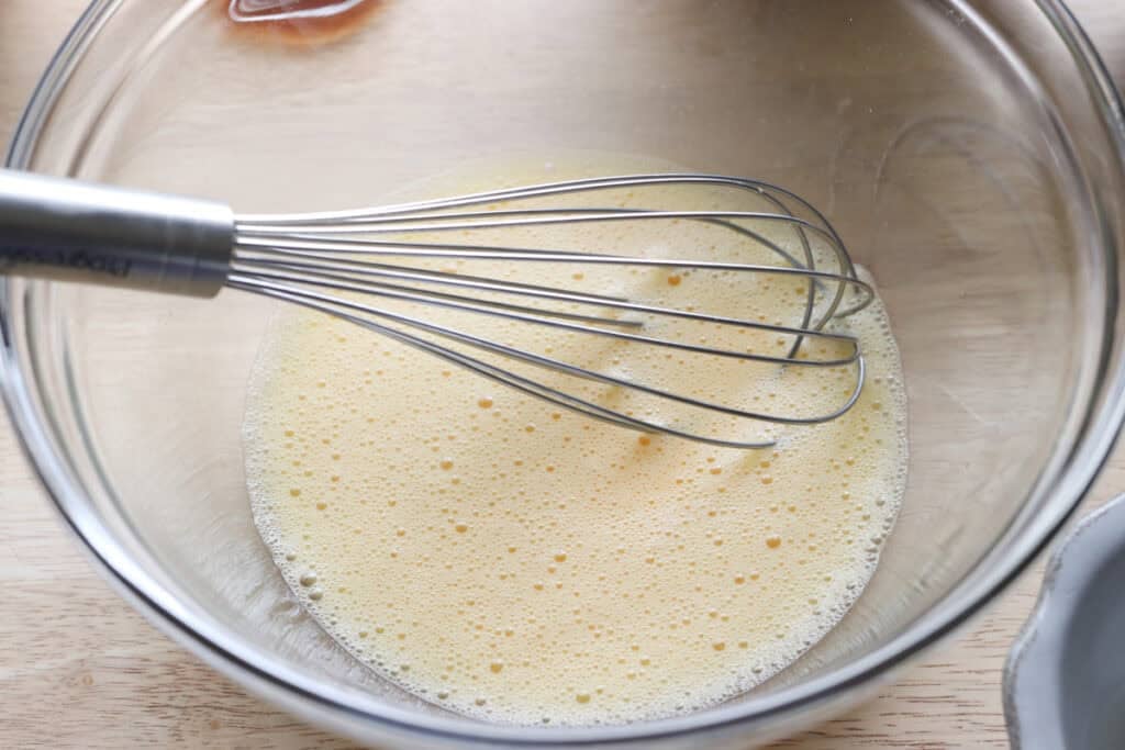 eggs whisked in a bowl to make Homemade Baked Spring Donuts with Fresh Milled Flour