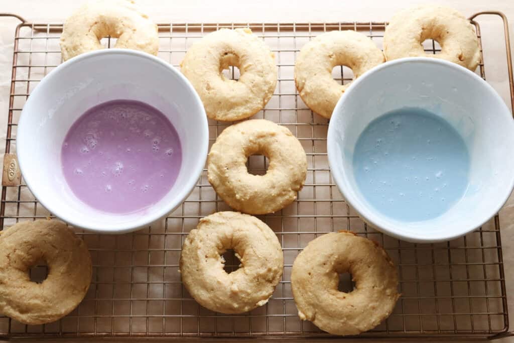 Homemade Baked Spring Donuts with Fresh Milled Flour on a wire rack with two bowls of glaze