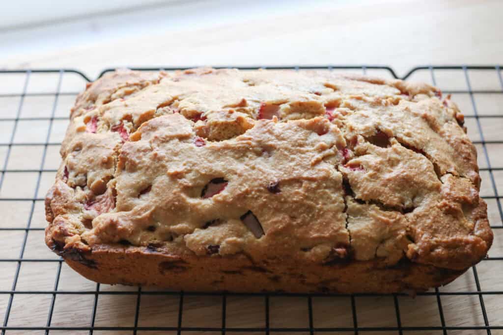 Freshly milled glazed strawberry bread that has been baked on a black cooling rack