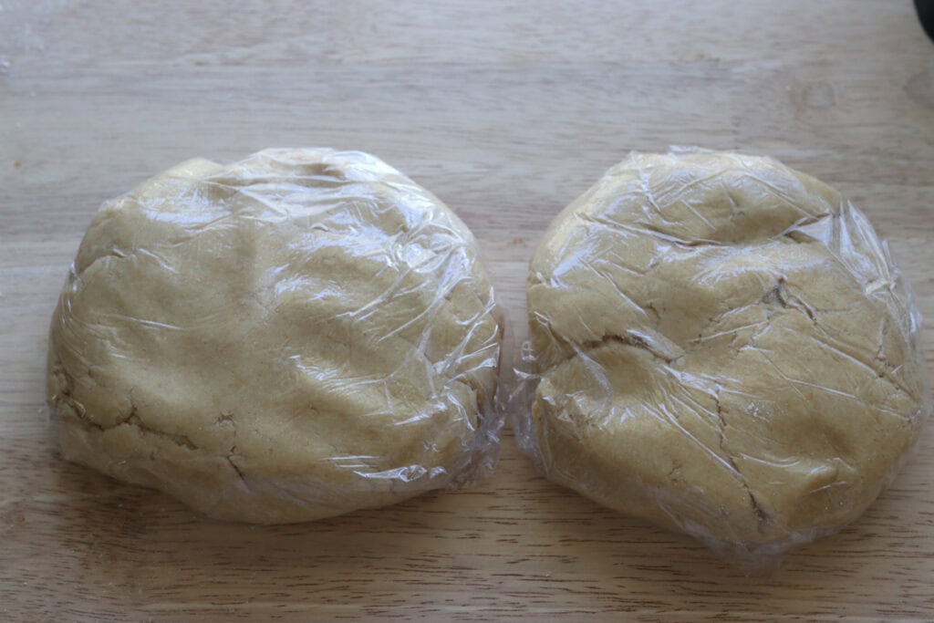 Fresh milled Easter egg sugar cookie dough divided in half and wrapped in plastic wrap