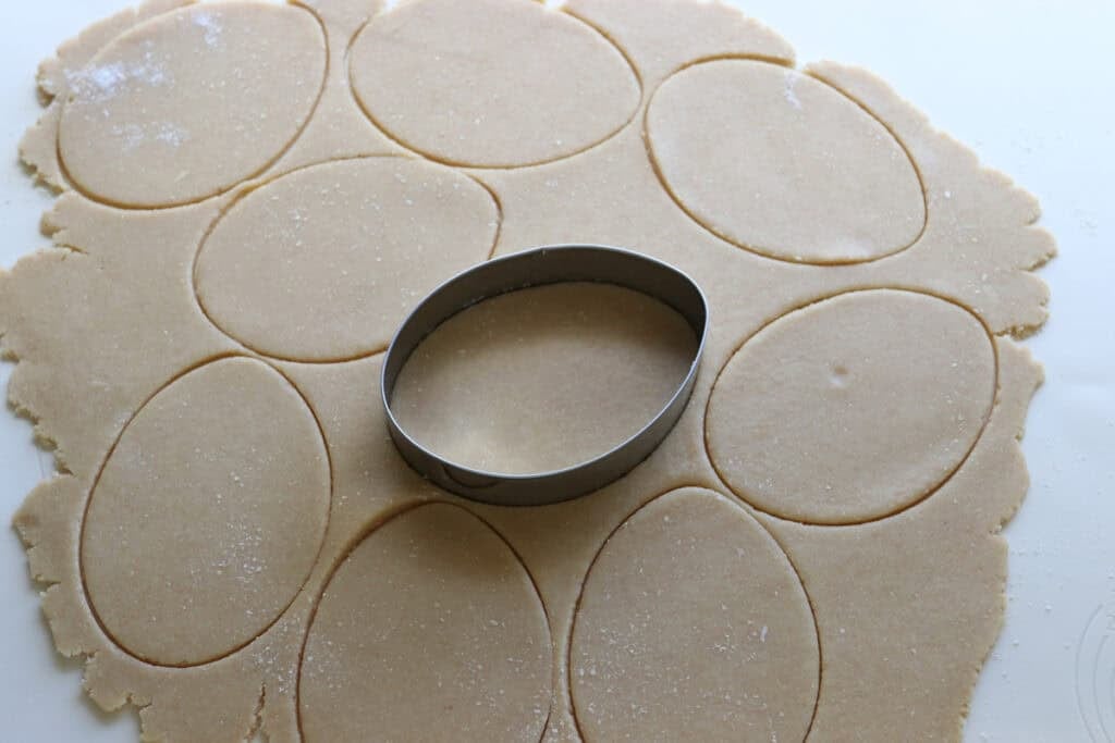Fresh milled Easter egg sugar cookie dough rolled out with an Easter egg cookie cutter