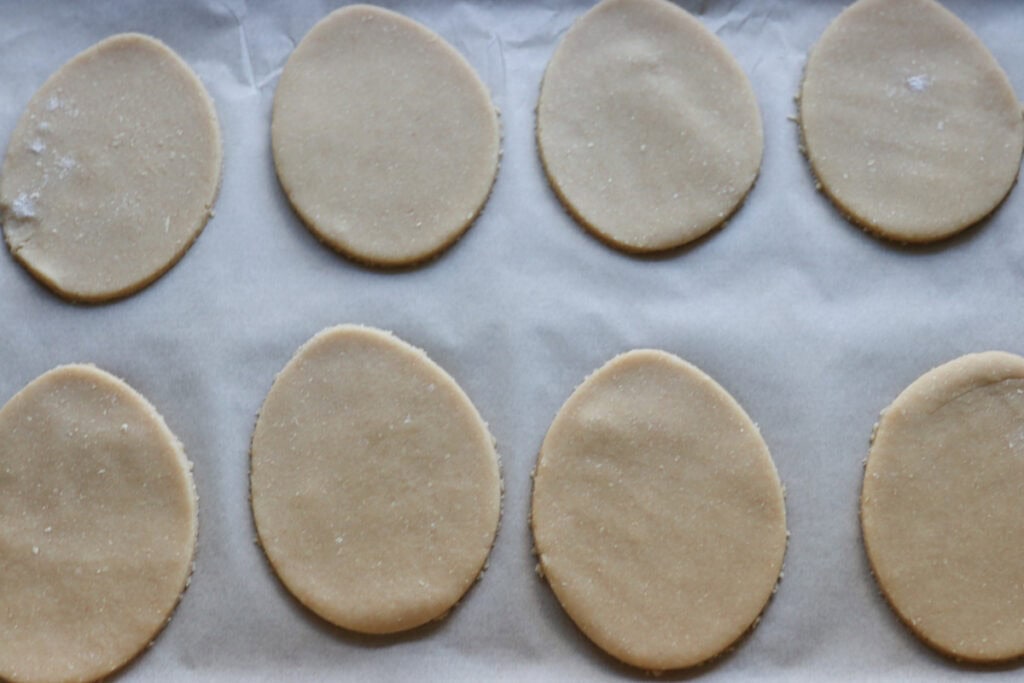 Fresh milled Easter egg sugar cookies on a baking sheet lined with parchment paper