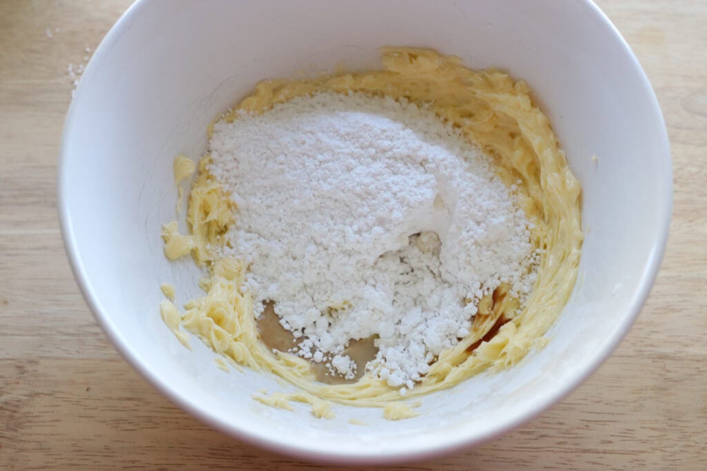 powdered sugar and butter in a bowl to make the icing for fresh milled Easter egg sugar cookies