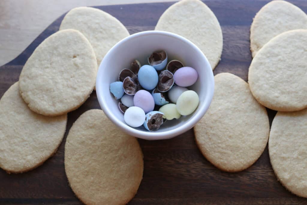 Fresh milled Easter egg sugar cookies on a wooden cutting board
