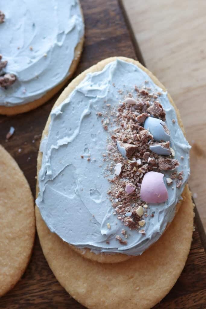 a Fresh milled Easter egg sugar cookie with blue frosting and chocolate eggs on top