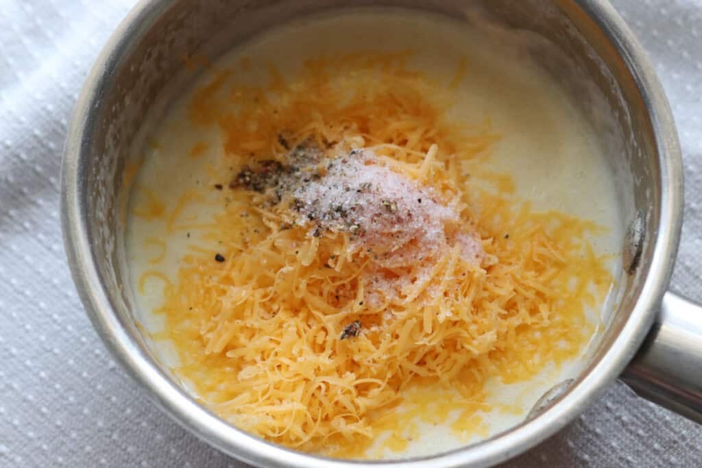 shredded cheese and salt added to the pot to make cheese dip for the Fresh Milled Soft Pretzel Bites