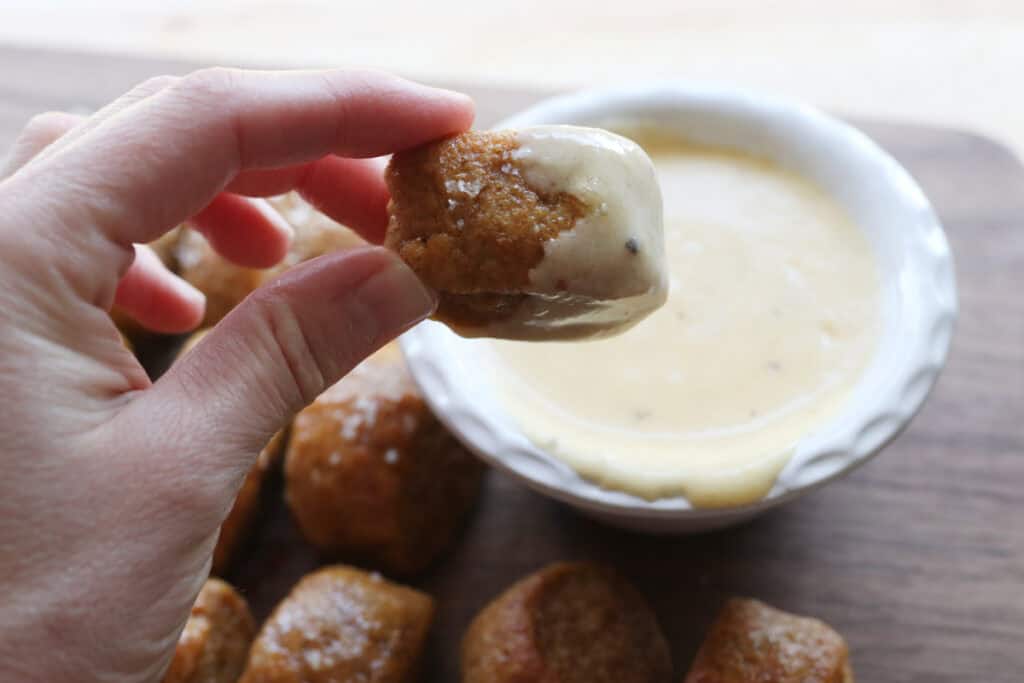 a Fresh Milled Soft Pretzel Bite dipped in cheese sauce