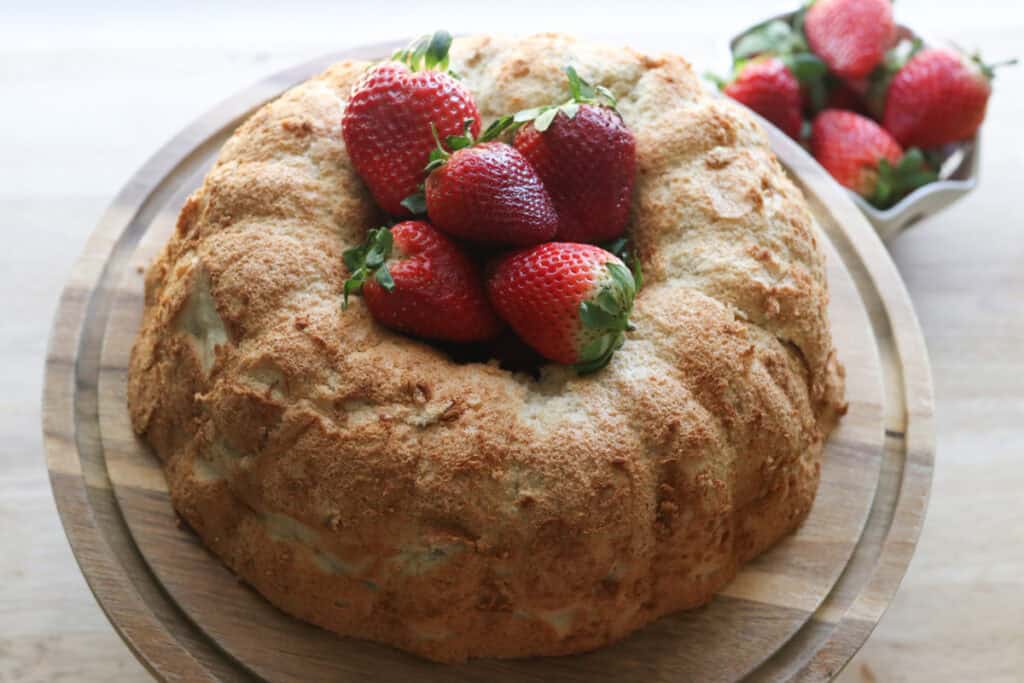 A freshly milled angel food cake with strawberries in the middle of it