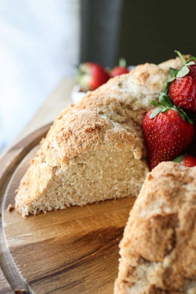 A freshly milled angel food cake that has been cut with strawberries on it