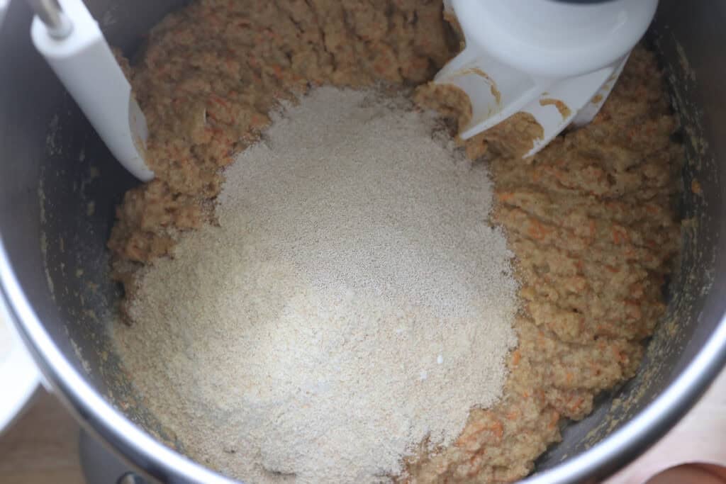 More flour added to the mixing bowl to make Fresh milled carrot cake cinnamon rolls