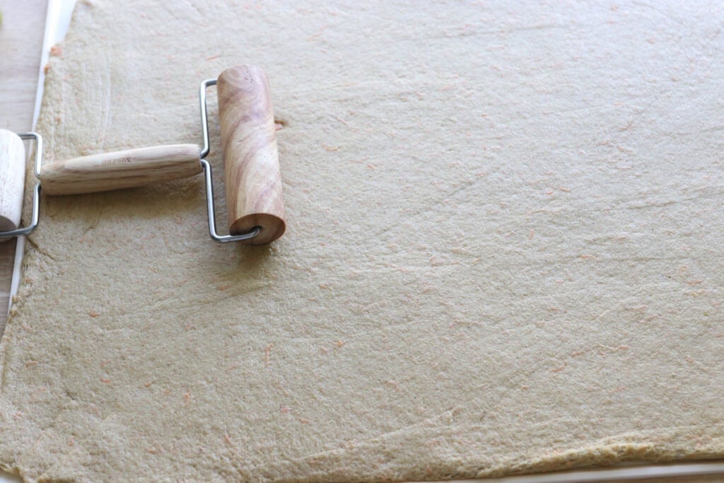 Fresh milled carrot cake cinnamon roll dough rolled into a rectangle