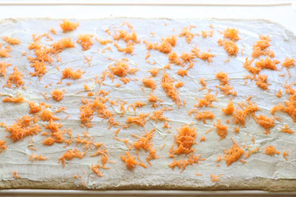 Shredded carrots added to Fresh milled carrot cake cinnamon roll dough