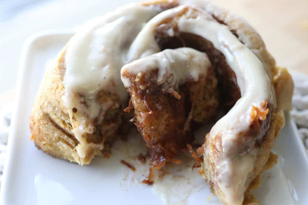 A Fresh milled carrot cake cinnamon roll cut in half