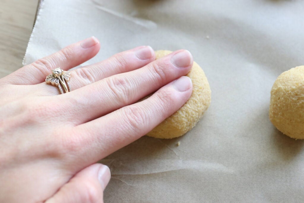 Pressing down fresh milled lemon cookies to make them flat