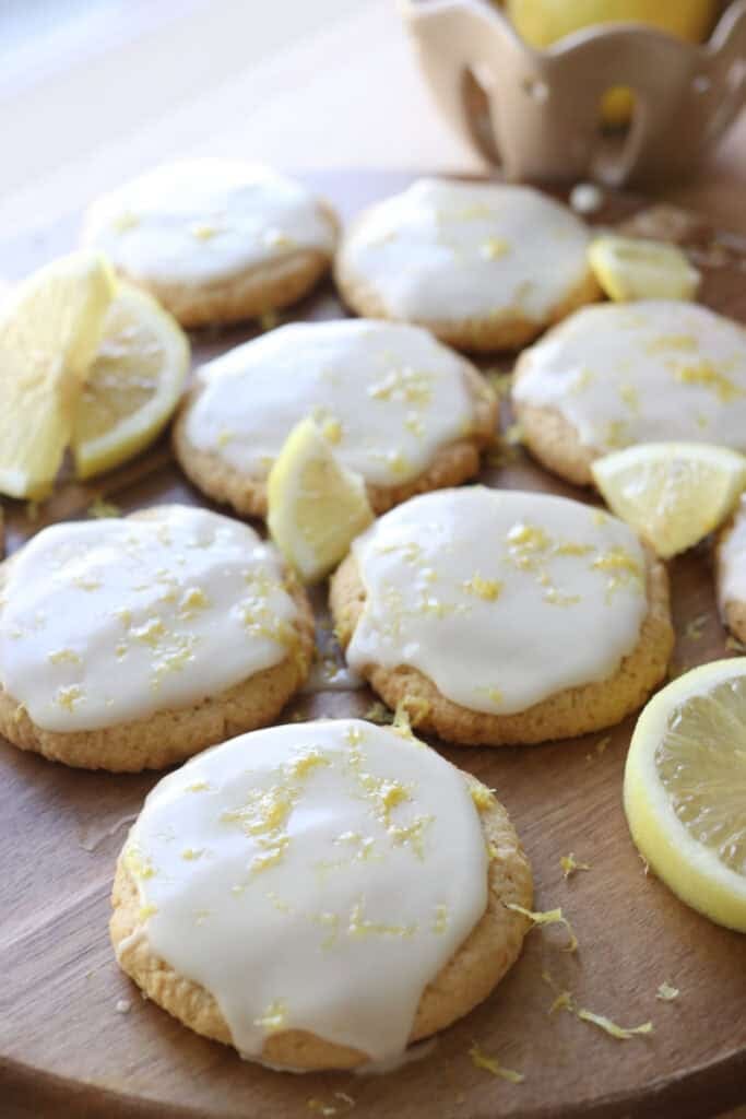 Fresh milled lemon cookies with a lemon glaze and lemon zest on a cutting board