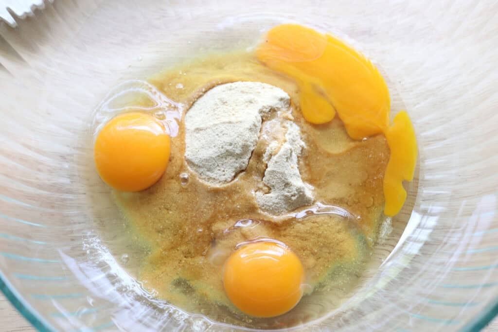 eggs, sugar, and almond extract in a glass mixing bowl to make the fresh milled almond croissant cake