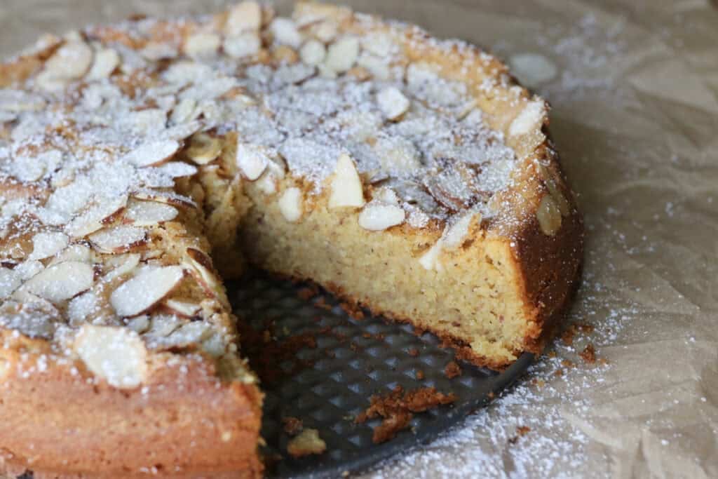 fresh milled almond croissant cake on a spring form pan topped with sliced almonds