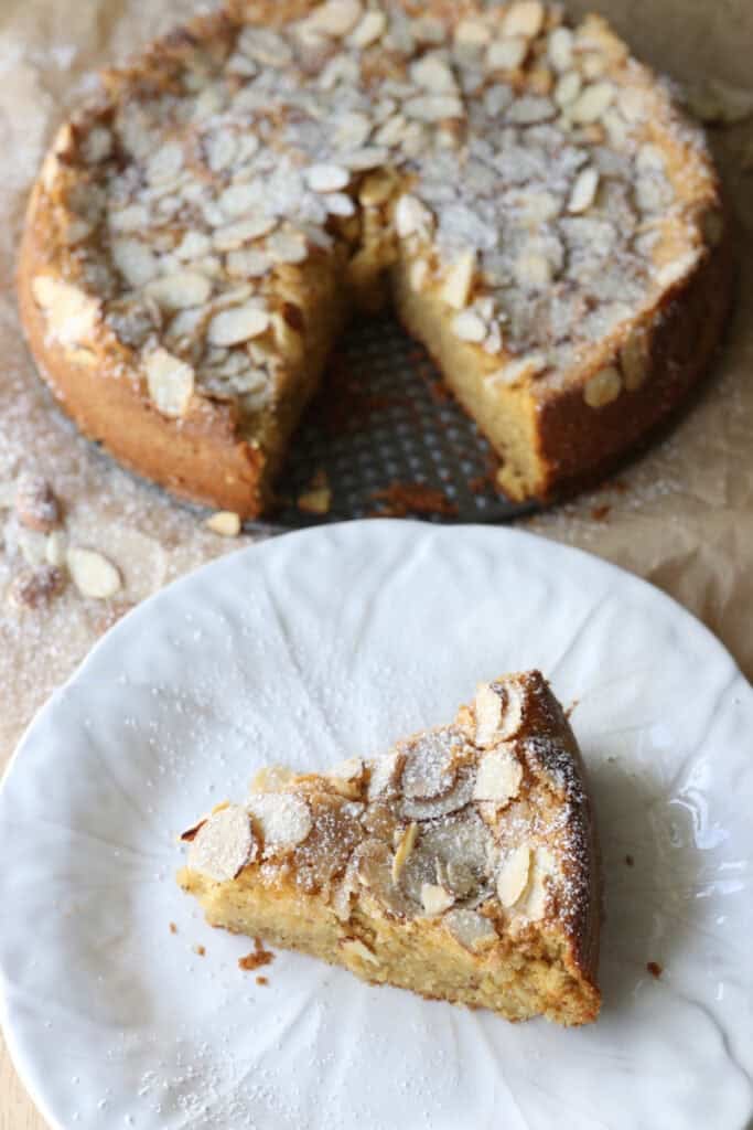 a slice of fresh milled almond croissant cake on a white plate