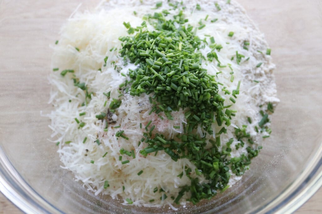flour, parmesan, and chives in a mixing bowl to make Easy Freshly Milled Parmesan Chive Drop Biscuits