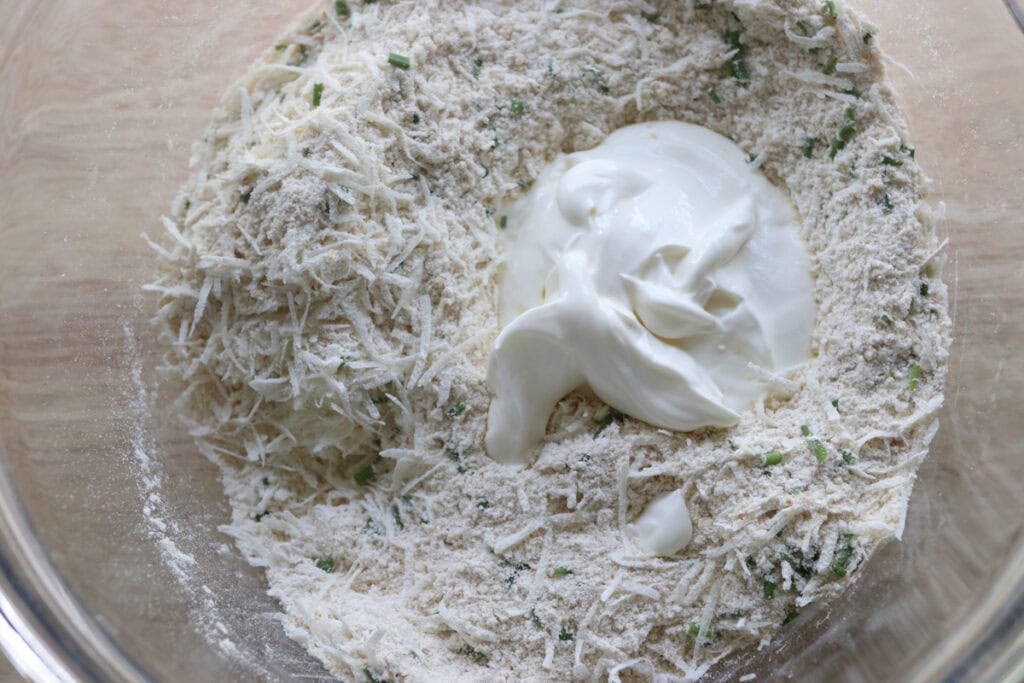 sour cream added to the bowl to make Easy Freshly Milled Parmesan Chive Drop Biscuits