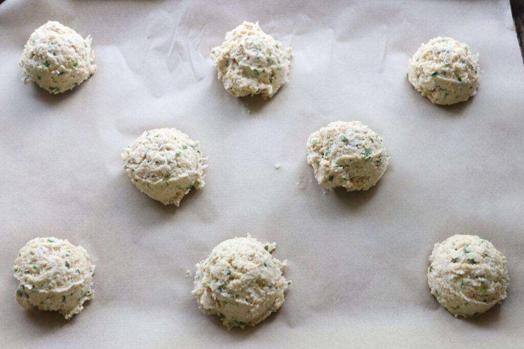 Easy Freshly Milled Parmesan Chive Drop Biscuits on a baking sheet with parchment paper