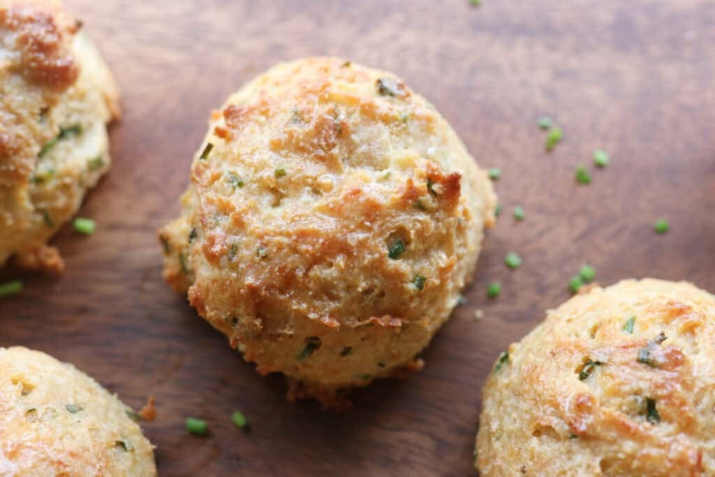 A Freshly Milled Parmesan Chive Drop Biscuit baked until golden brown on a board