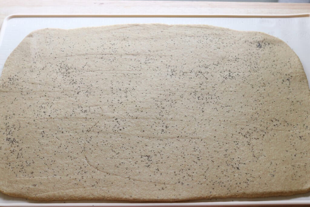 freshly milled lemon poppy seed dough rolled out into a rectangle