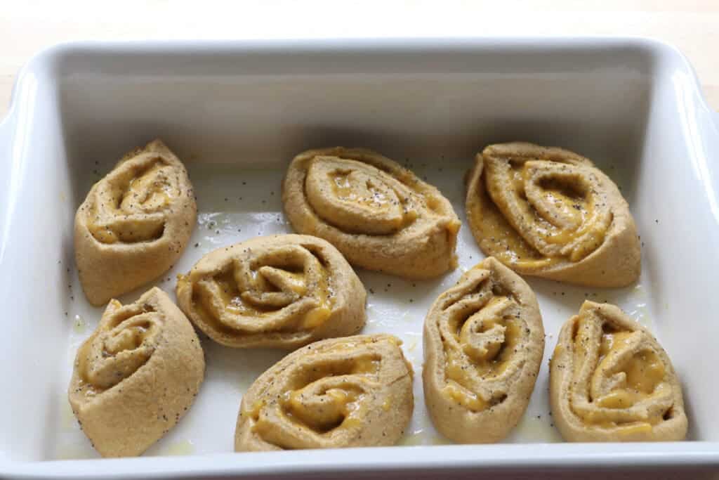 freshly milled lemon poppy seed rolls placed in a dish to rise