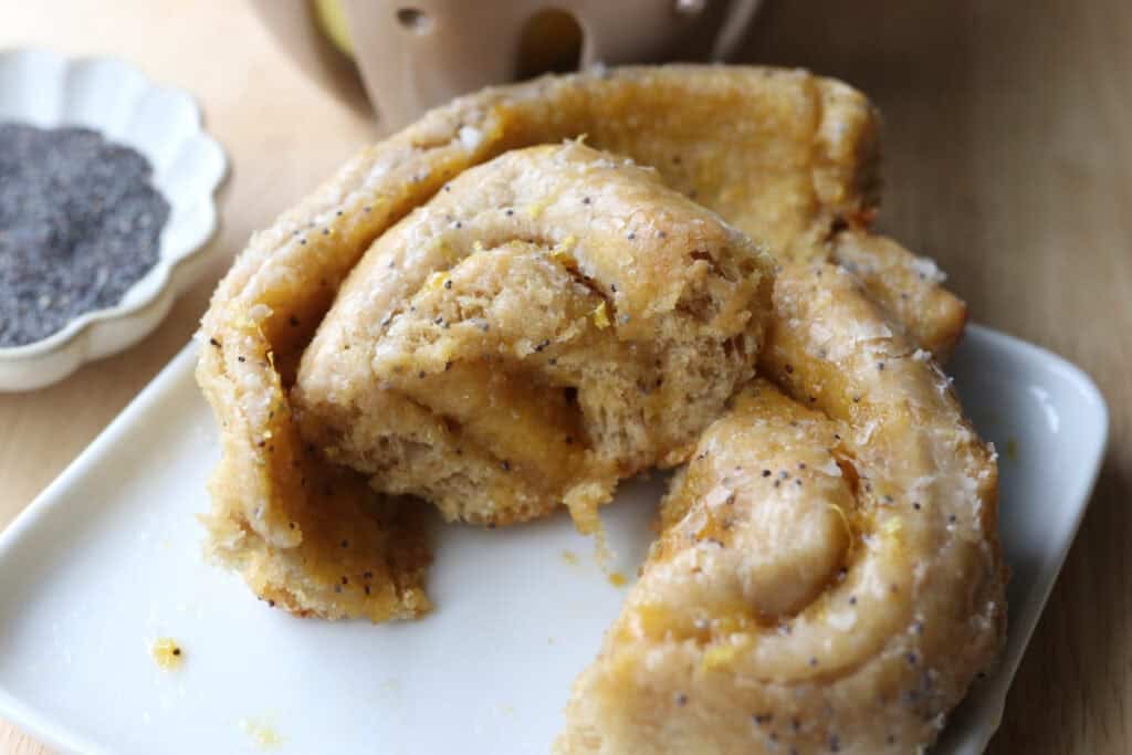 a freshly milled lemon poppy seed roll on a plate cut in half