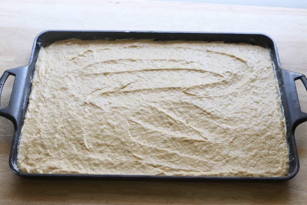 freshly milled frosted banana bar batter spread into a baking pan 