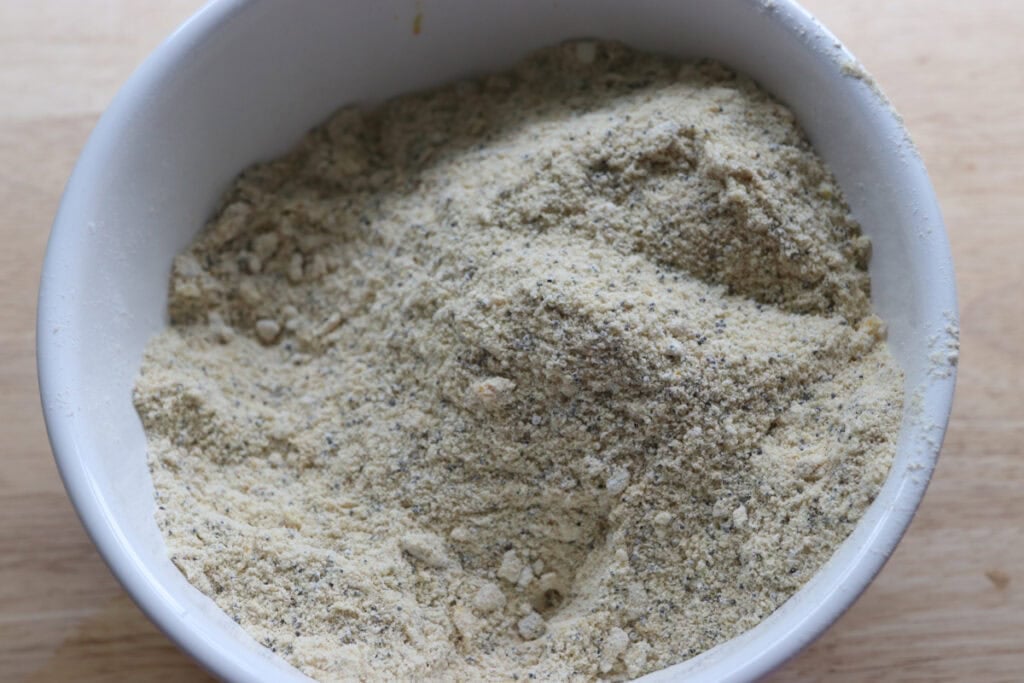 flour and orange zest stirred together in a bowl for the Freshly milled orange almond poppy seed cake