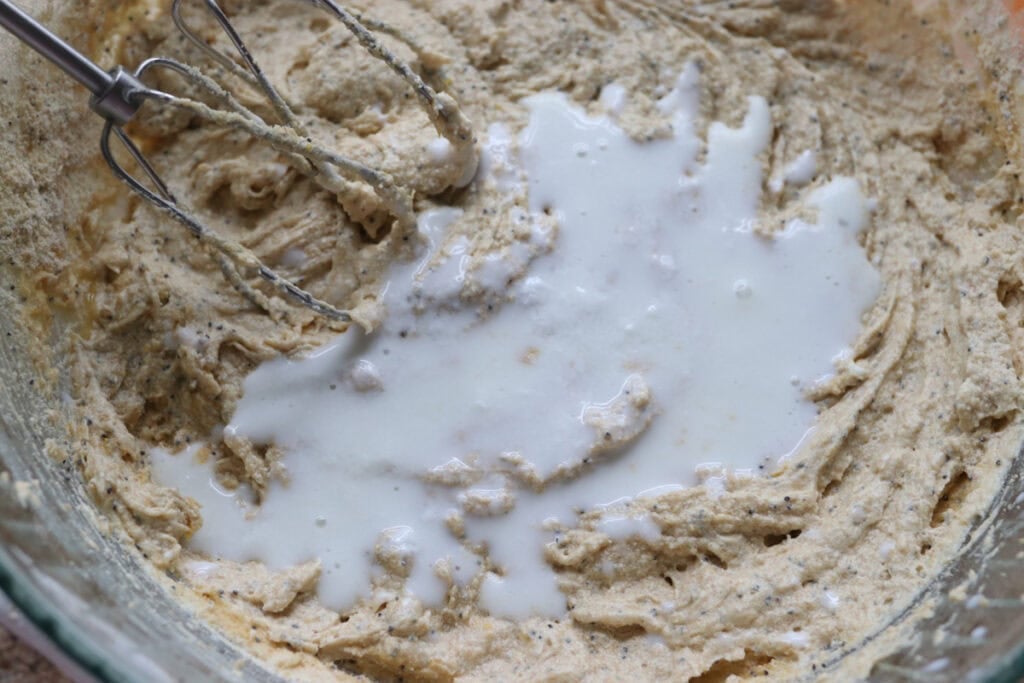 adding buttermilk to the Freshly milled orange almond poppy seed cake batter