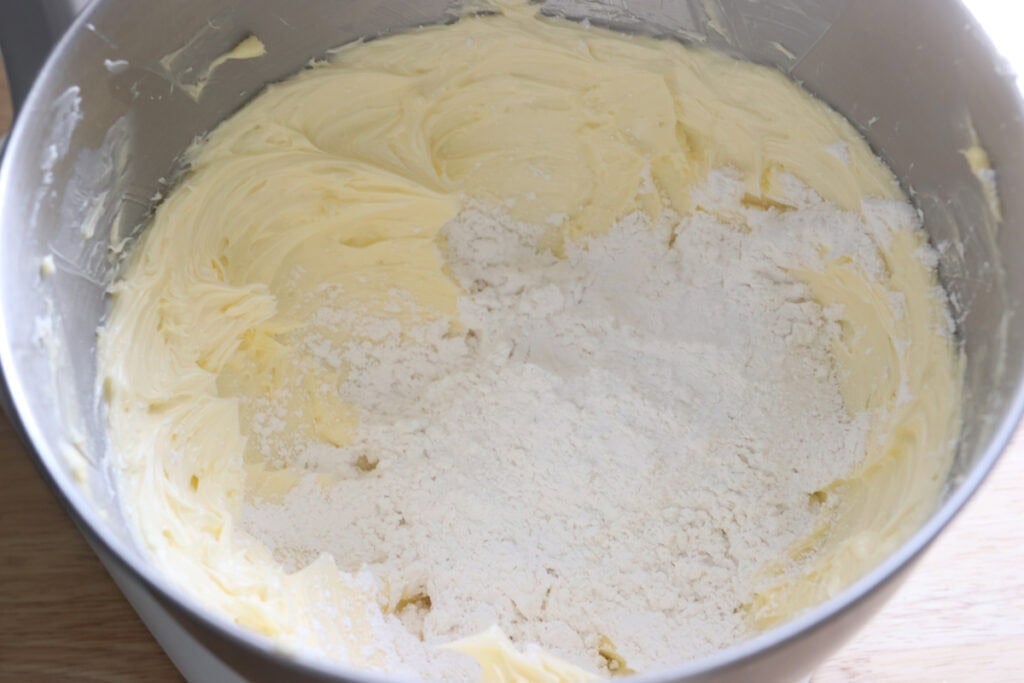 sifted powdered sugar added to the bowl for the buttercream for Freshly milled orange almond poppy seed cake