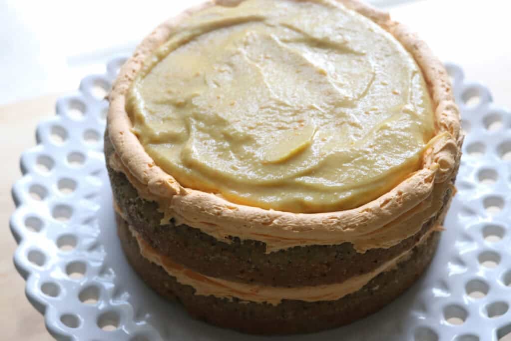 two layers of Freshly milled orange almond poppy seed cake with buttercream and lemon curd