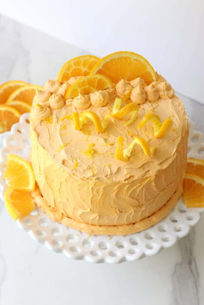 Freshly milled orange almond poppy seed cake with orange slices on it