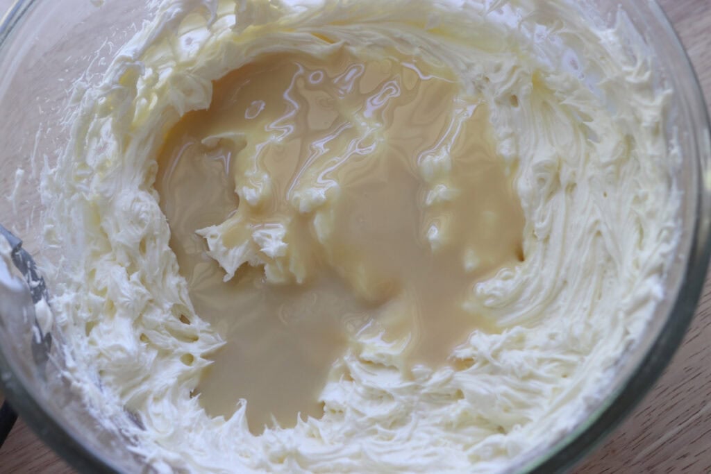 sweetened condensed milk added to cream cheese to make freshly milled mango cheesecake bars