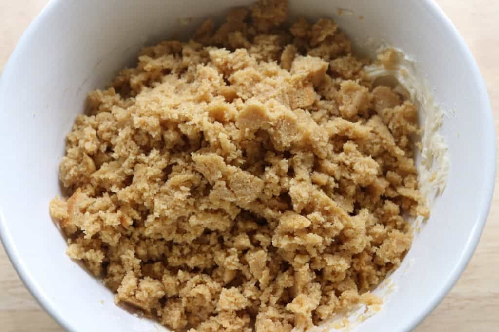Freshly milled cake crumbled into a bowl of icing to make Freshly milled cake pops