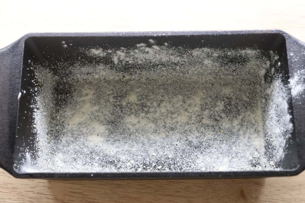 cornmeal and butter in a loaf pan for the freshly milled english muffin toasting bread